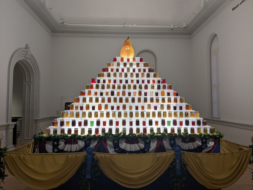 Many jars of preserved fruits and vegetables displayed in an array.