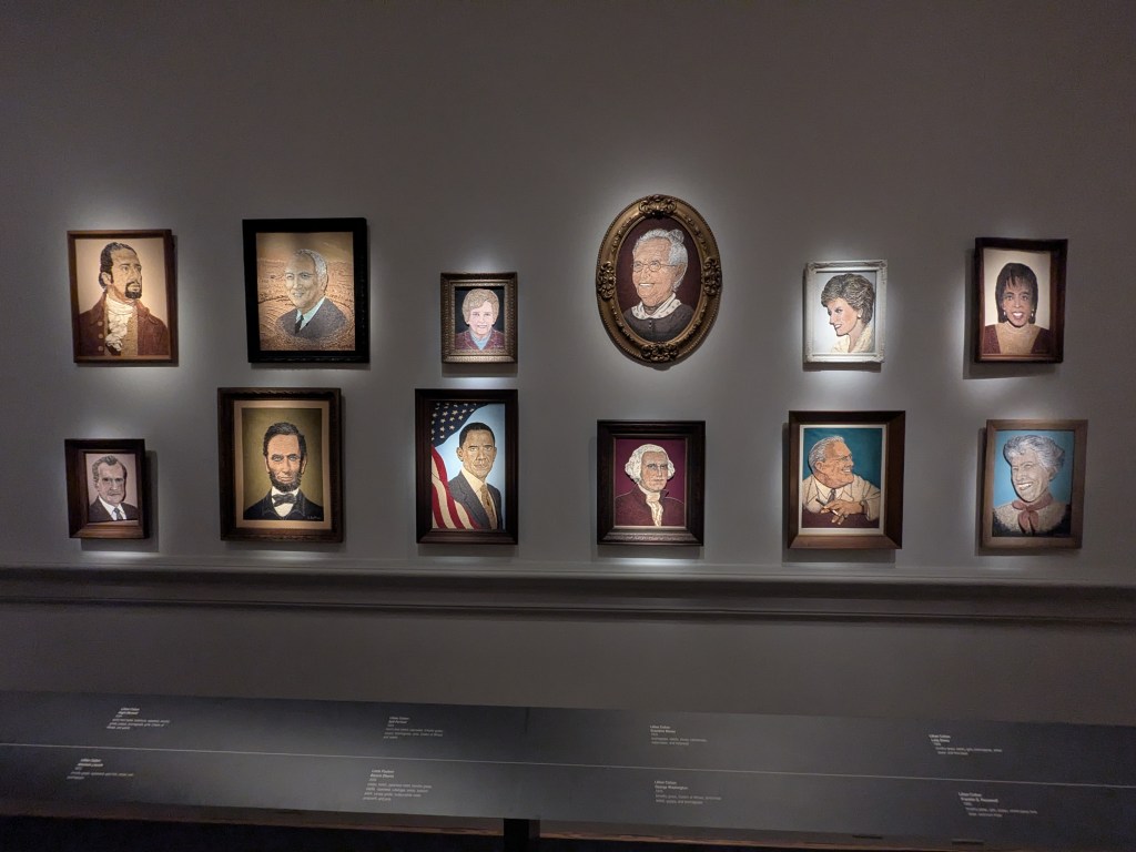 Portrait images of people mounted and lit in a museum environment.